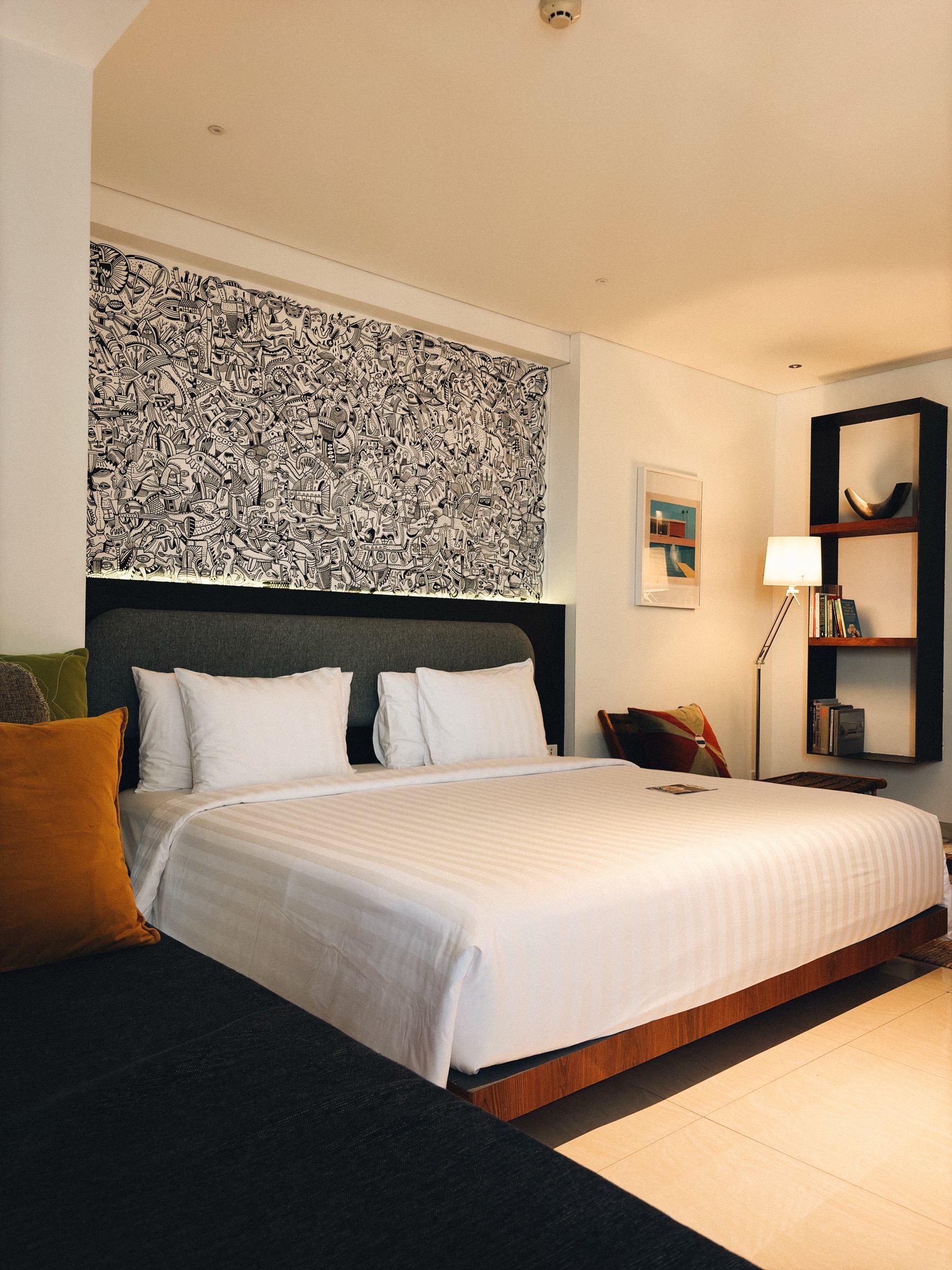 King bed beneath a backlit black-and-white doodle mural in a PULANG ke UTTARA room
